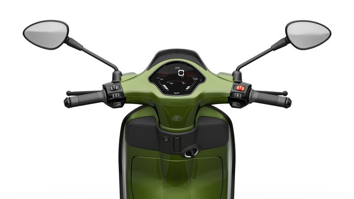 A close-up view of the handlebars and dashboard of a green scooter, featuring two mirrors, a digital speedometer displaying zero speed, and various controls on the handle grips.