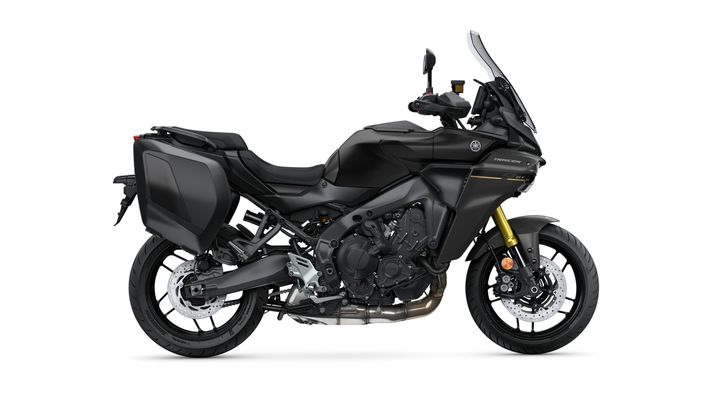A sleek black touring motorcycle with a sporty design, featuring side panniers, a tall windshield, and gold front forks, set against a white background.