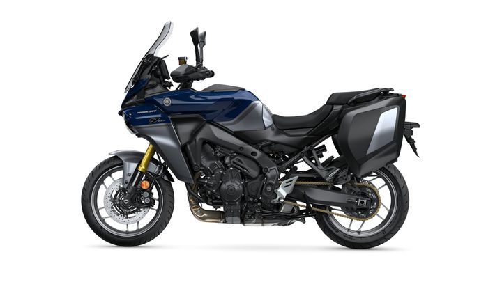 A side view of a blue Yamaha motorcycle with a large windshield, mounted mirrors, and saddle bags, showcasing a sleek design and advanced features.