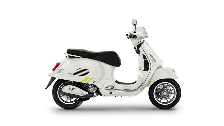 A sleek white scooter with black accents and a modern design, viewed from the side, showcasing its profile and intricate wheel details.