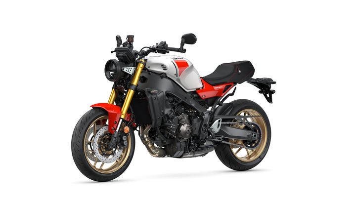 A modern motorcycle with a sleek design, featuring a white and red body, gold-colored rims, and a black frame. The bike is viewed from the side, highlighting its sporty look and details like the exhaust and handlebars.
