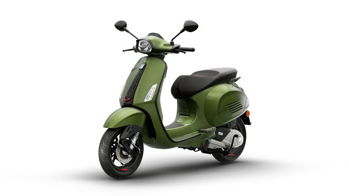 A green vintage-style scooter with a sleek design, featuring a black seat, round headlights, and chrome accents, positioned on a white background.