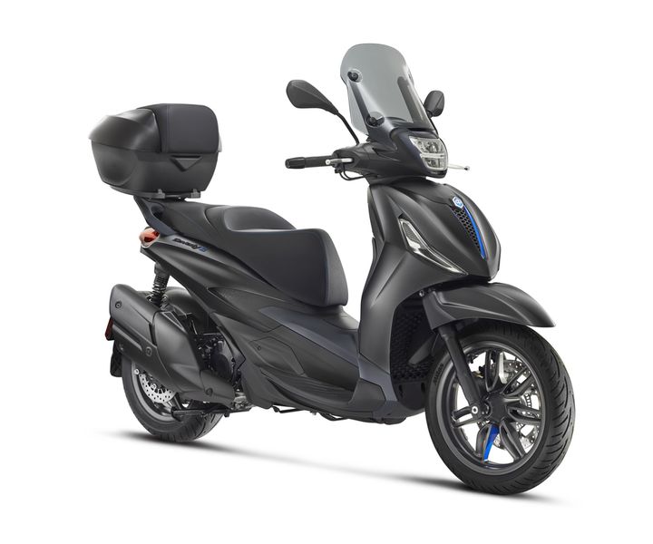 A sleek black scooter with a clear windshield, a high back seat, and a rear storage compartment, positioned at an angle to highlight its design and features.
