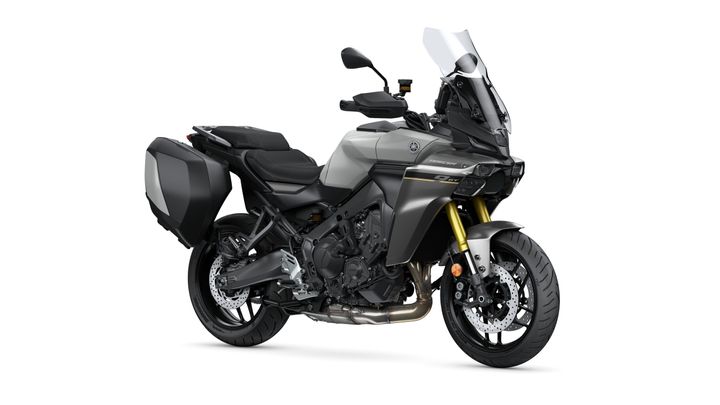 Yamaha 2025 TRACER 9 GT Y-AMT A sleek, modern motorcycle with a metallic gray body, gold front forks, and black side panniers, positioned at a slight angle to showcase its design and features.