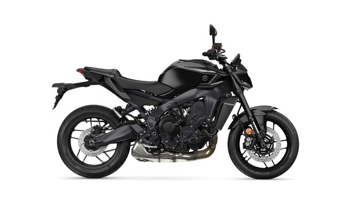 A sleek, black modern motorcycle is displayed side-on, showcasing its sporty design, bold frame, and performance tires against a white background.