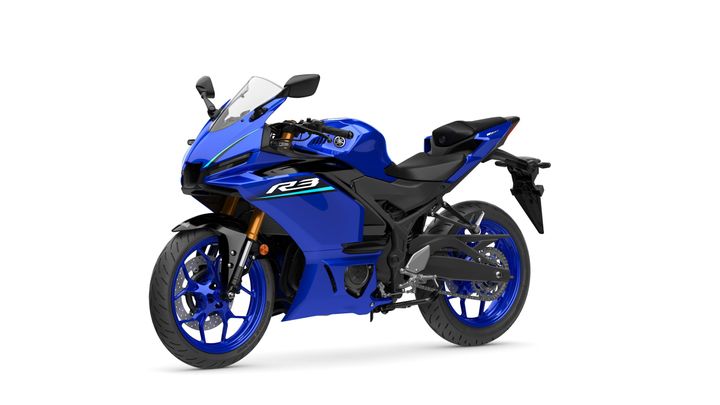A blue Yamaha R3 motorcycle with a sleek design, featuring a fairing, coated wheels, and a modern seating arrangement, positioned against a white background.