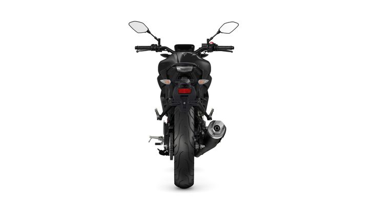 A rear view of a black motorcycle showcasing its sleek design, tail light, and exhaust.