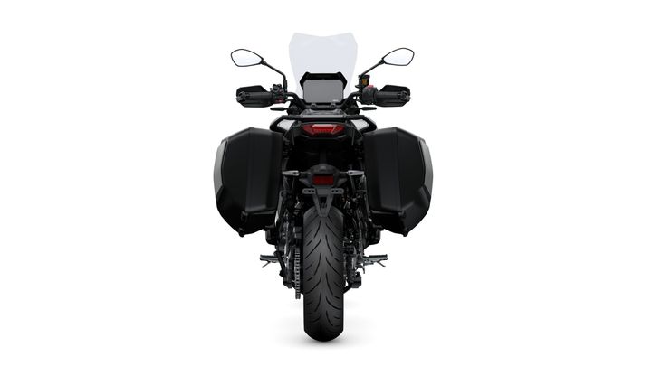 A rear view of a black adventure motorcycle featuring side panniers, a high windshield, and dual mirrors. The bike has a prominent rear tire and a sleek, modern design.