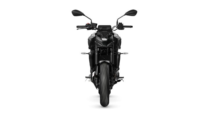 A sleek, black motorcycle viewed head-on, showcasing its aggressive design, sharp headlights, and prominent front tire.