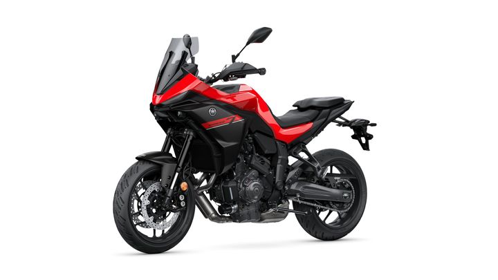 A red and black Yamaha motorcycle, model Tracer 7, displayed at an angle, highlighting its aerodynamic design, large wheels, and sporty appearance against a white background.