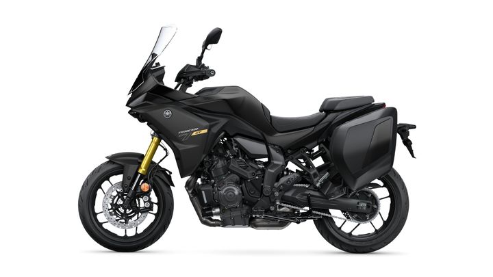 A sleek black Yamaha Tracer 7 GT motorcycle, featuring a sporty design with a large windshield, gold front suspension, and rear storage bags, positioned on a white background.