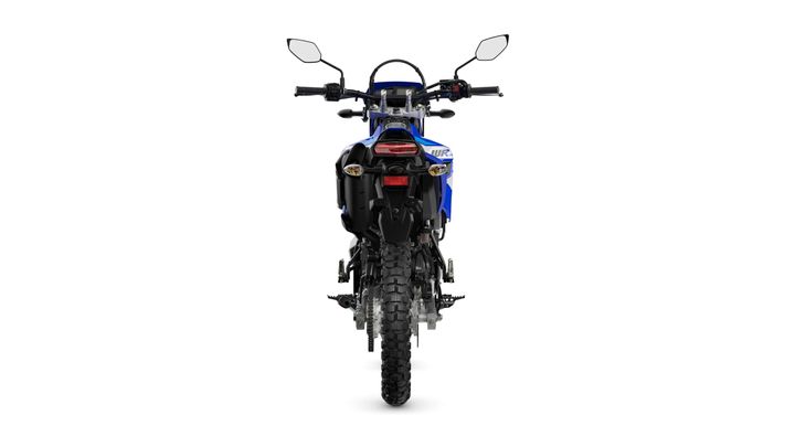 A blue off-road motorcycle viewed from the rear, showcasing the tire, tail light, and handlebars.