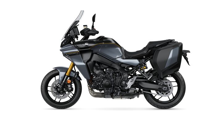 A sleek, modern touring motorcycle in metallic gray with black accents, featuring a windshield, large side luggage, and a powerful engine visible beneath the frame.