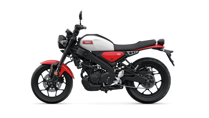 A sleek Yamaha motorcycle in black, red, and white, showcasing a modern design with a minimalist aesthetic, viewed from the side.