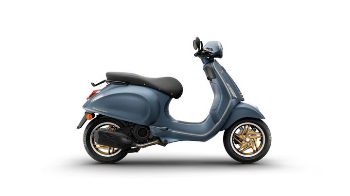 A side view of a stylish blue scooter with black leather seat and gold wheels, set against a white background.