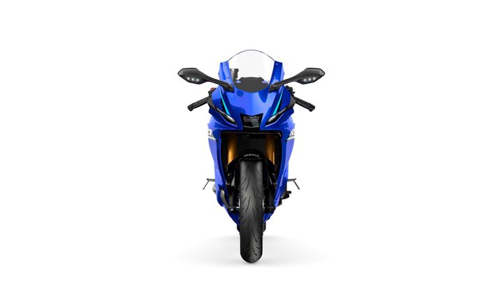 A blue sports motorcycle viewed from the front, showcasing its streamlined design, sharp headlights, and large front tire against a white background.