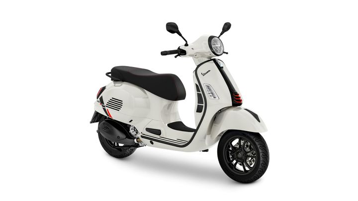 A white scooter with black accents and a modern design, featuring a comfortable seat and stylish wheels, positioned in a three-quarter view.