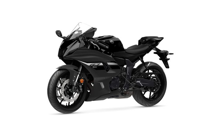 A sleek, black sport motorcycle positioned at an angle, showcasing its aerodynamic design, prominent front fairing, and detailed wheel and brake components.