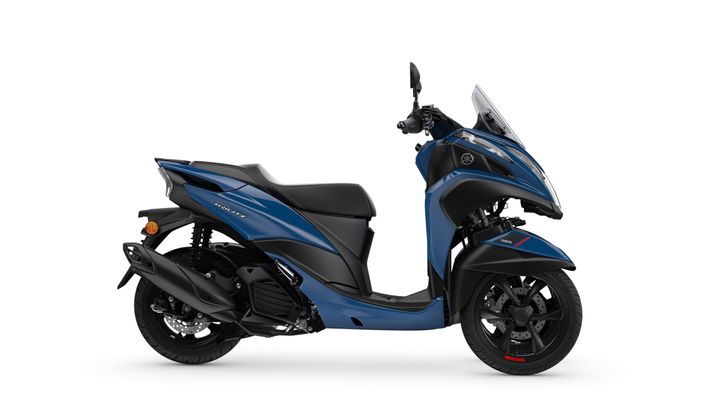 A blue scooter with a sleek design, featuring two front wheels, a windscreen, and a black seat, displayed against a white background.