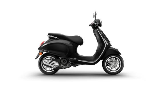 Vespa Primavera 50 MY26 A sleek black scooter is shown from the side, featuring a curved body, comfortable seat, and shiny wheels, set against a white background.