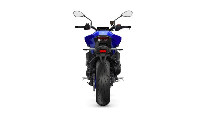 A blue motorcycle is shown from the rear, featuring a wide rear tire, dual taillights, and an upright seat with handlebars extending upward. The background is plain white.