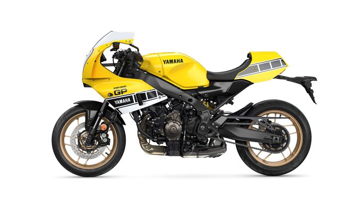 A yellow and black Yamaha XSR900 GP motorcycle in a side view, showcasing its sporty design, distinctive graphics, and gold alloy wheels.