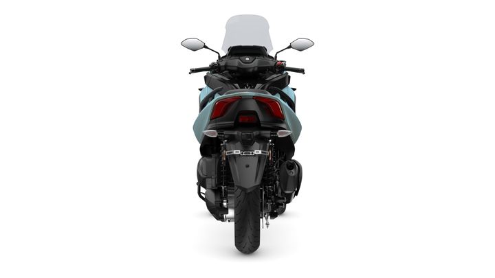 A rear view of a blue motorcycle with a sleek design, showing the taillights, exhaust, and rear tire against a white background.