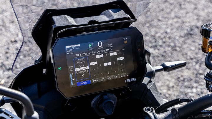 Close-up of a Yamaha motorcycle's digital dashboard displaying data like the current mode, speed, ride control settings, and trip information on a clear display.