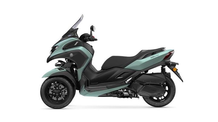A sleek, modern scooter in a blue-green and black color scheme, featuring a large windshield and sporty design elements.